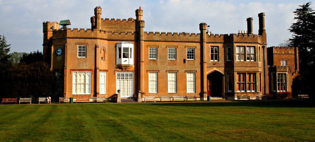 Nonsuch Mansion's Tudor Gothic facade and crenellated towers viewed across the lawn in Cheam.
