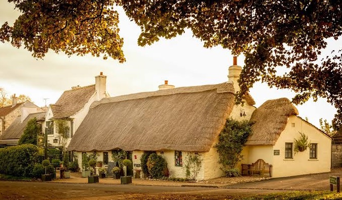 The thatched exterior of The Star Inn at Harome in warm evening light.